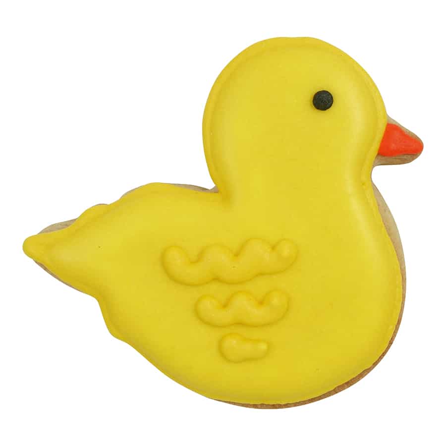 A decorated duck-shaped sugar cookie covered in yellow icing with an orange beak and black eye detail, featuring textured wing patterns for added design.