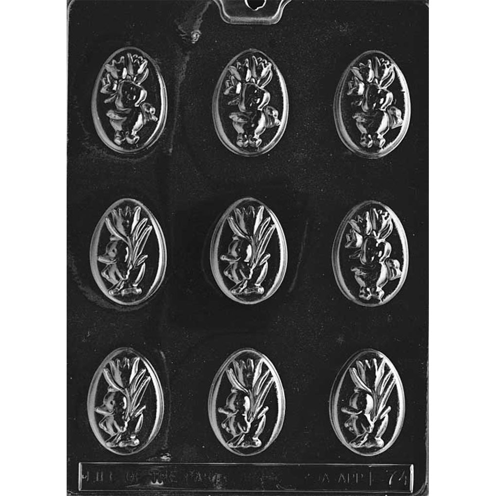 Ducklings with flowers chocolate mold featuring nine oval cavities on a dark plastic tray, each cavity showing a raised duckling and leafy flower sprig cameo design.