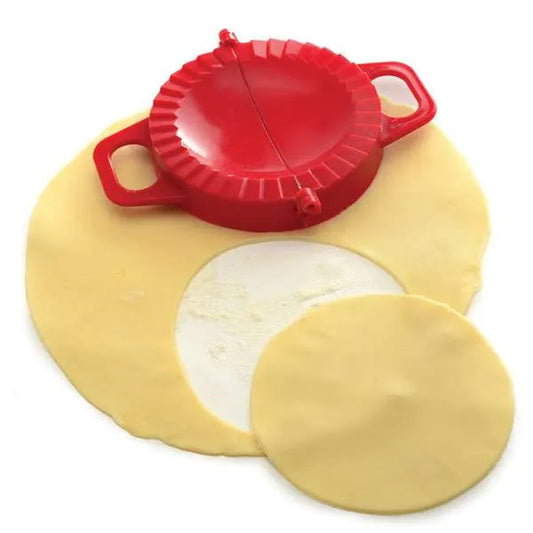 Dough press on rolled dough, with a perfect circle cut out for filling and folding.