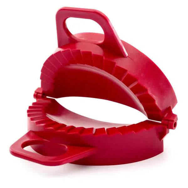 Red dumpling dough press shown open, with crimped edges and ergonomic handles.