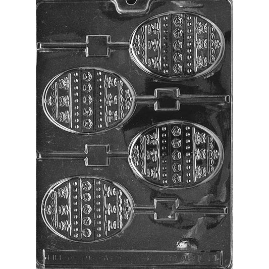Clear plastic chocolate lollipop mold with four egg-shaped cavities featuring raised striped patterns with dots and small decorative motifs, each connected to a stick channel on a dark background.
