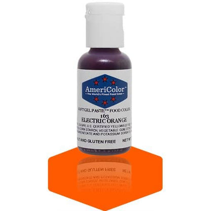 A bottle of AmeriColor Electric Orange soft gel paste food coloring with a white cap and blue label featuring red stars, standing on a vibrant orange reflective surface that mirrors the bottle.