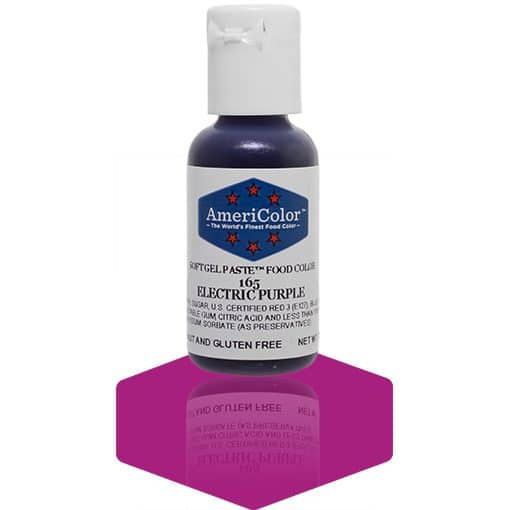 A bottle of AmeriColor Electric Purple soft gel paste food coloring with a white cap and blue label featuring red stars, standing on a deep purple reflective surface that mirrors the bottle.