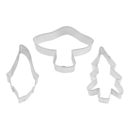 Three metal cookie cutters shaped like a gnome, a mushroom, and an evergreen tree arranged on a white background.