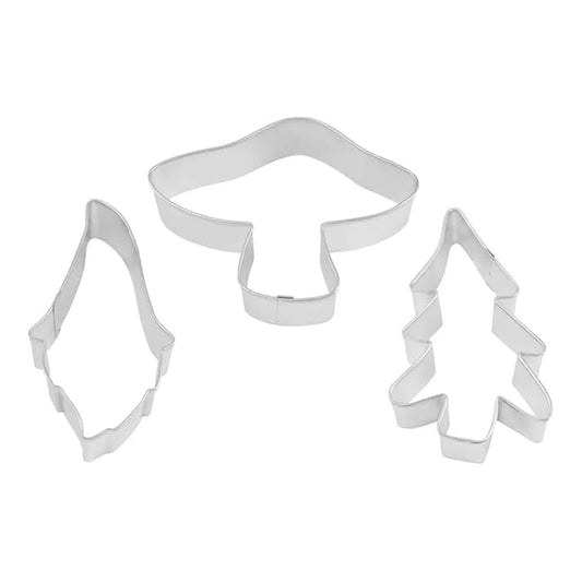 Three metal cookie cutters shaped like a gnome, a mushroom, and an evergreen tree arranged on a white background.