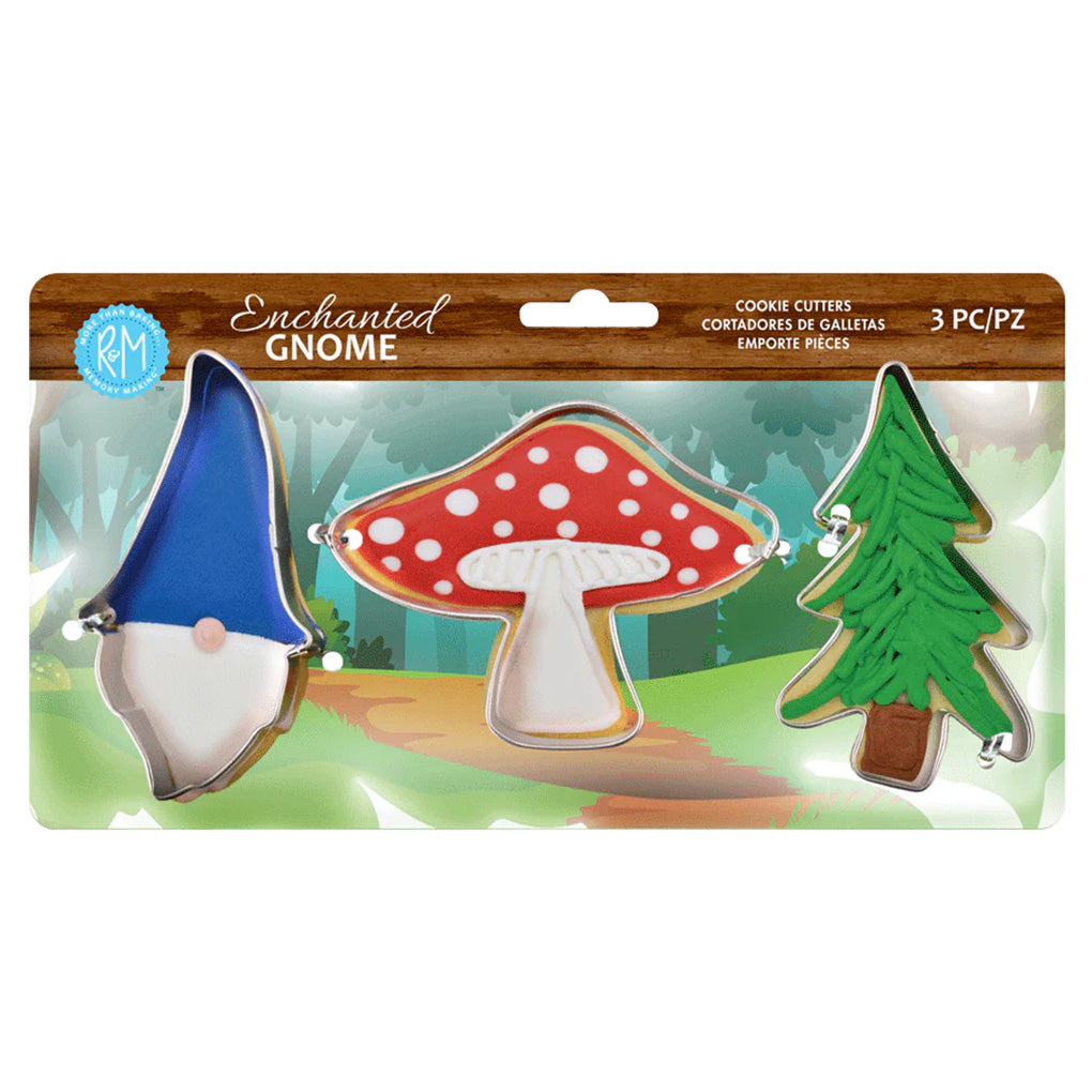 Packaged Enchanted Gnome 3-piece cookie cutter set showing decorated example cookies of a blue-hat gnome, red spotted mushroom, and green evergreen tree.