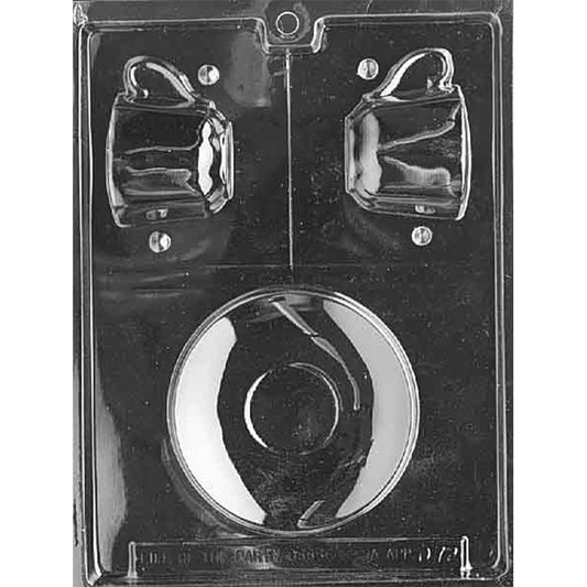 Clear plastic chocolate mold photographed against a black background with cavities for two small espresso cups at the top and a round saucer cavity centered below.