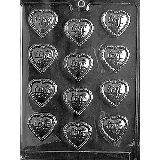 Clear chocolate mold with 12 small heart-shaped cavities, each embossed with the word Love and finished with a decorative border on a dark background.