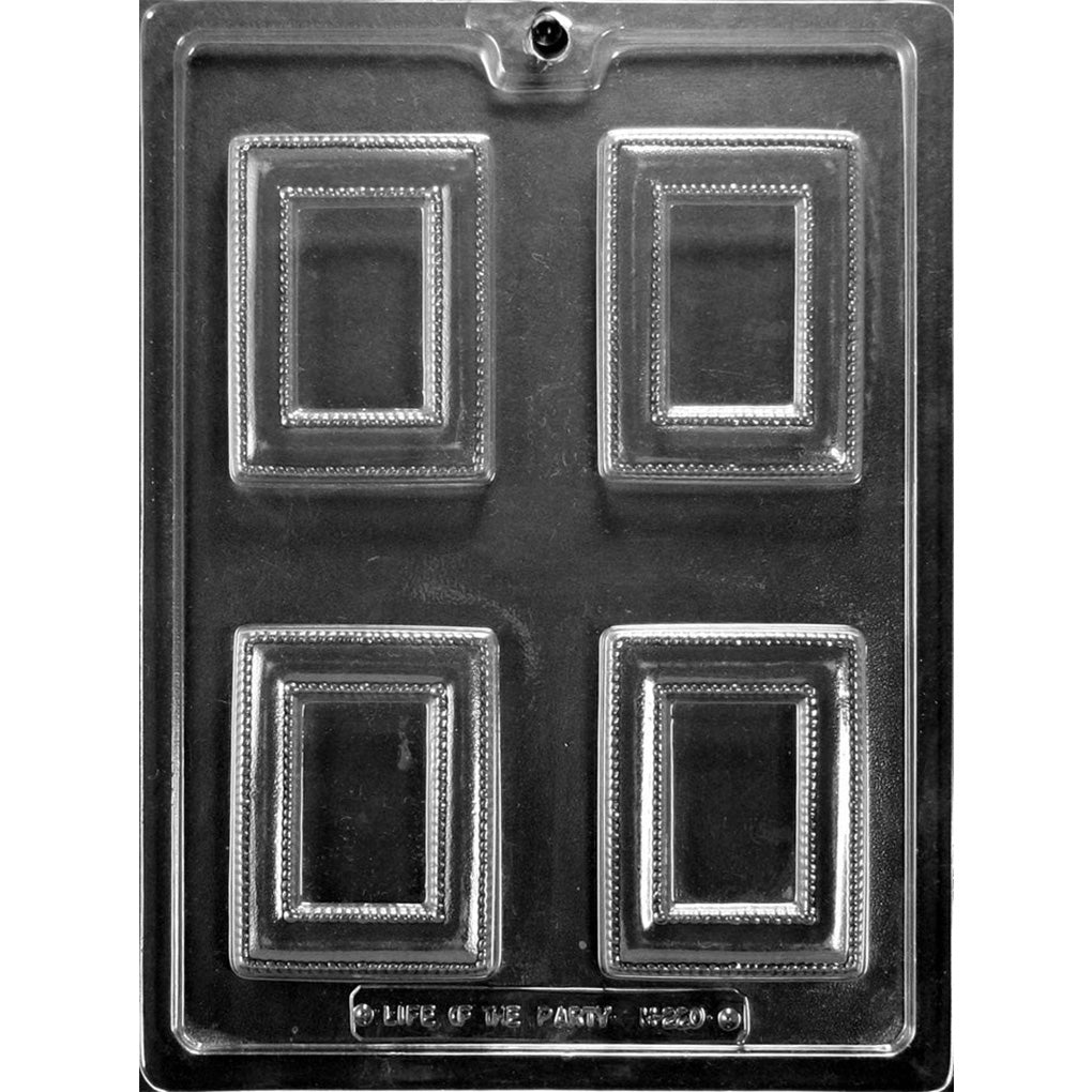 Clear plastic chocolate mold with four rectangular fancy picture frame cavities featuring raised ornate borders and beaded edge details on a dark background.