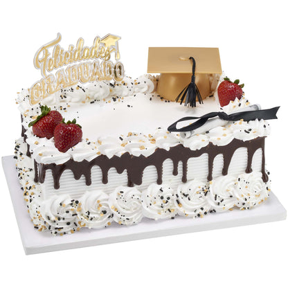 White rectangular cake with chocolate drip, whipped frosting swirls, strawberries, a gold graduation cap decoration, and a Felicidades Graduado cake topper placed on top.