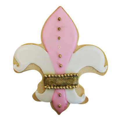 Decorated Fleur De Lis-shaped sugar cookie with pink and white icing, gold accents, and small edible pearls.