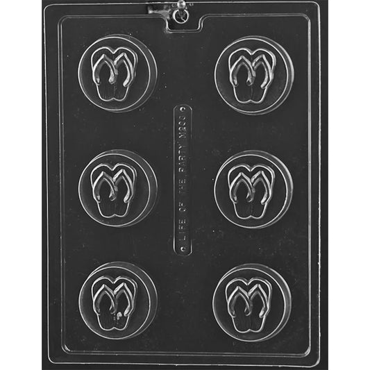 Clear plastic chocolate mold with six round cavities, each featuring a raised flip-flop sandal design centered inside a circular border.