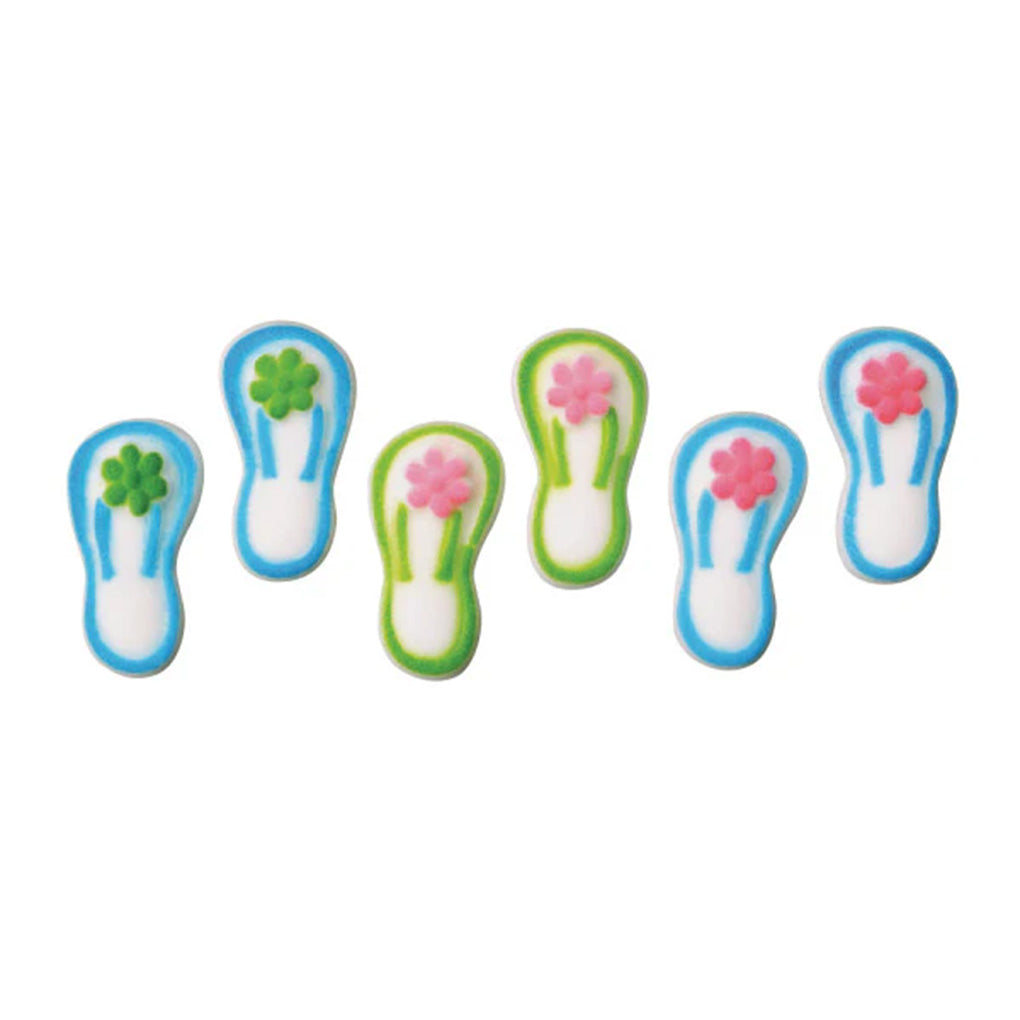 Six pressed sugar flip flop decorations with white centers, blue or green borders, and small flower accents on the straps, arranged on a white background.