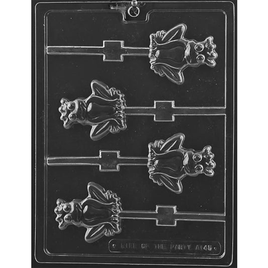 Clear plastic chocolate lollipop mold with four smiling frog prince cavities featuring crowns, large round eyes, webbed feet, and channels for sticks.