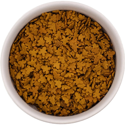 Top-down view of a round container filled with brown gingerbread boy-shaped sprinkles, showing small flat figures packed closely together.