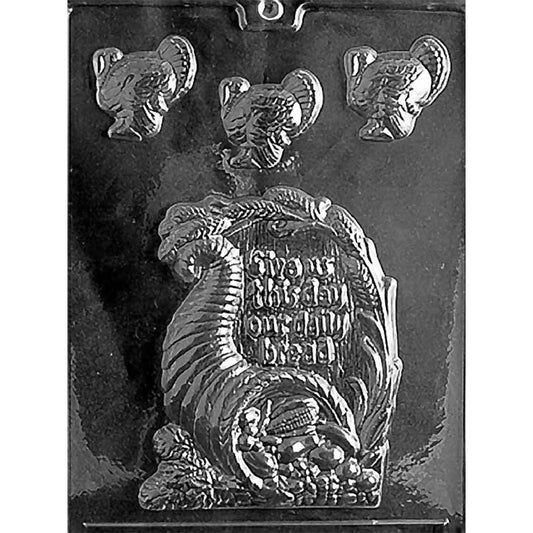 Thanksgiving chocolate mold with one large cornucopia plaque reading “Give Us This Day Our Daily Bread” and three small turkey cavities.
