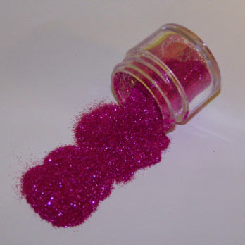 Deep pink Galaxy Glitter Dust pouring from a jar, catching light with a bold magenta sparkle.