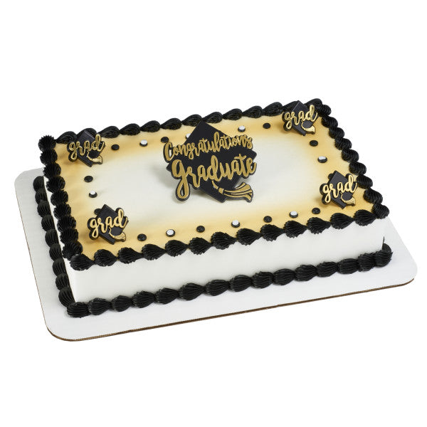 Rectangular graduation cake with black icing border, gold “Congratulations Graduate” topper, and small “Grad” plaques.