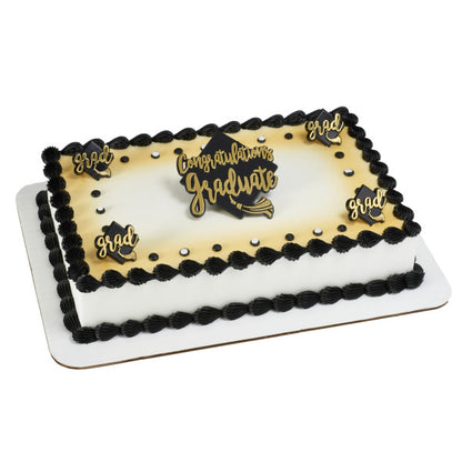 Rectangular graduation cake with black icing border, gold “Congratulations Graduate” topper, and small “Grad” plaques.