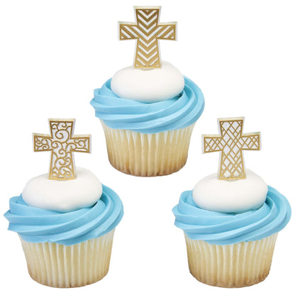 Three cupcakes with blue frosting and white centers, each decorated with a different gold cross cupcake pick in lattice, chevron, or scrolling patterns.