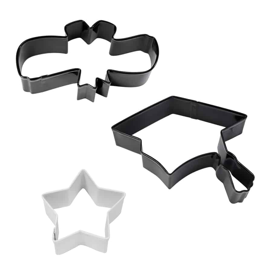 Three metal cookie cutters shaped like a graduation cap, diploma, and star in black and white.