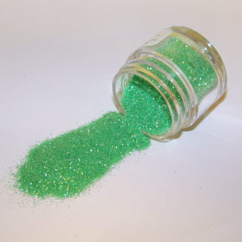 Light green Galaxy Glitter Dust spilled from a clear jar, sparkling with soft, minty shimmer and subtle gold flecks.