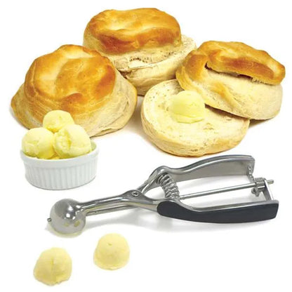 #96 stainless steel cookie scoop displayed with biscuits and several round butter portions to demonstrate its 2-teaspoon scoop size.