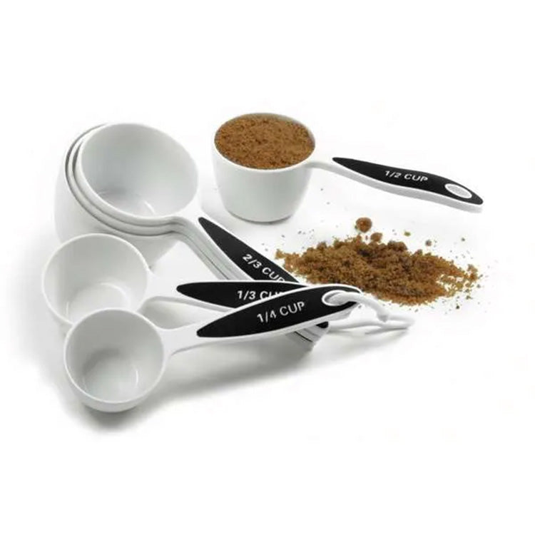 Grip-EZ measuring cups on a ring beside a filled measuring cup and spilled brown sugar, with size labels visible on the handles.