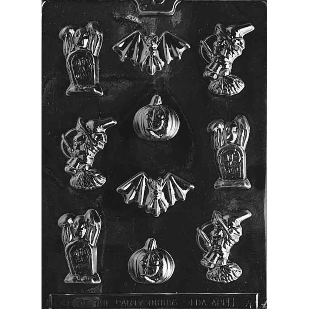 Clear Halloween assortment chocolate mold photographed on a black background with cavities shaped like a ghost behind a gravestone, a witch on a broom, a bat, and a jack-o’-lantern pumpkin.