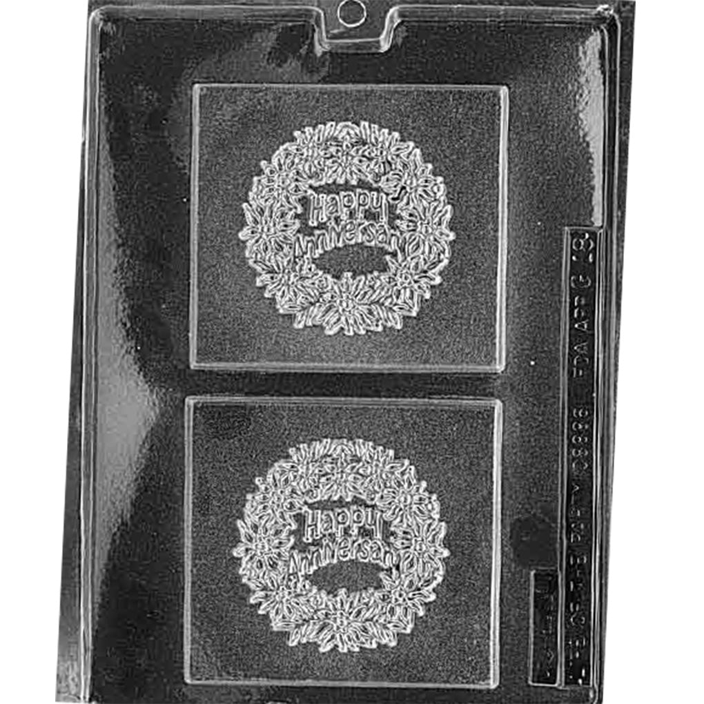 Clear plastic chocolate mold with two square plaque cavities featuring a raised floral wreath and the words “Happy Anniversary” in the center.