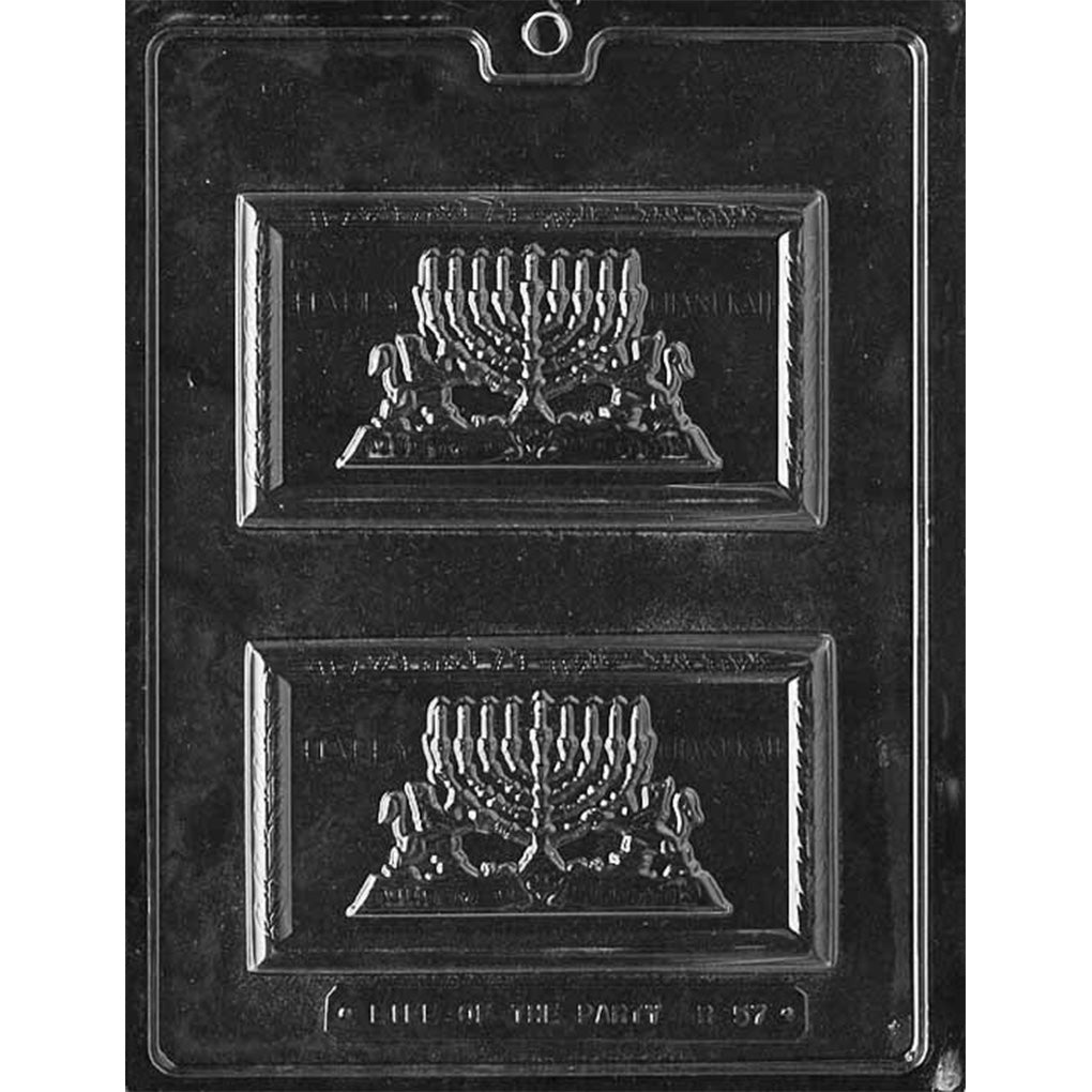 Clear plastic chocolate bar mold with two rectangular cavities featuring a raised menorah design and the words “Happy Chanukah” for casting themed chocolate bars.