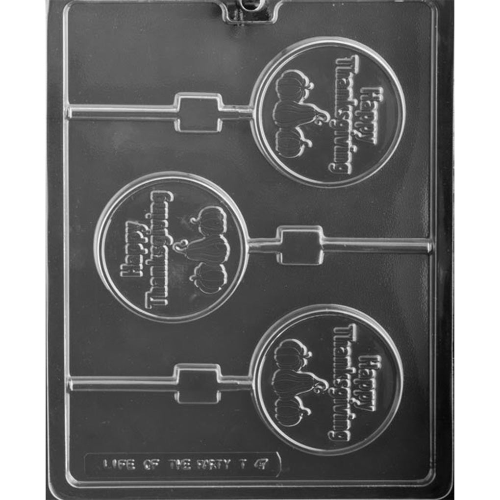 Clear chocolate lollipop mold with three round cavities featuring raised “Happy Thanksgiving” lettering above three pumpkins, each connected to a straight stick channel.
