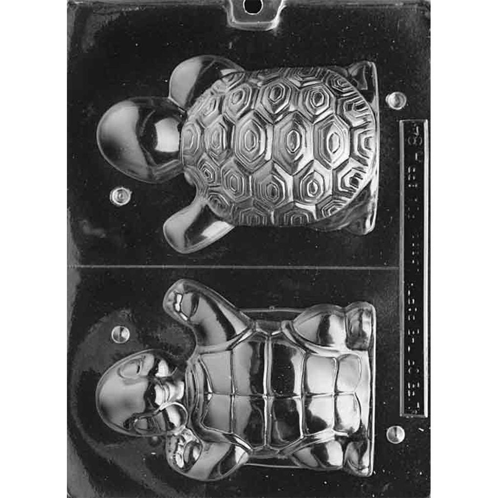 Clear plastic 3D chocolate mold photographed on a black background with two large turtle-shaped halves, showing a geometric patterned shell on one half and a smiling turtle underside on the other.