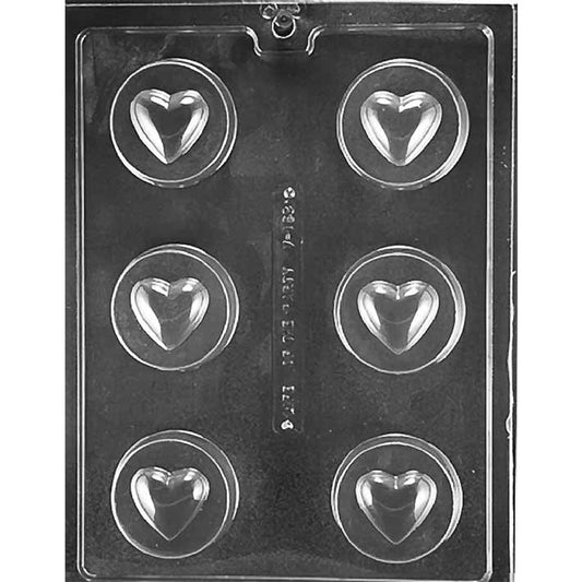 Clear plastic chocolate mold with six round cavities, each featuring a raised heart center inside a circular border, arranged in two columns on a dark background.