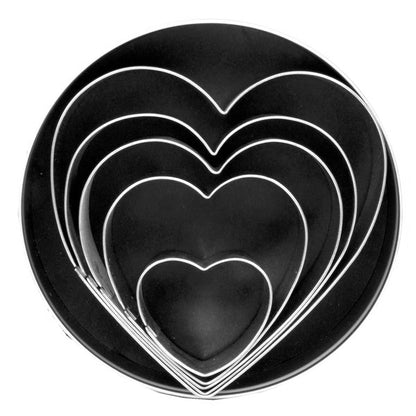 Set of five heart-shaped cookie cutters nested inside a black storage tin.