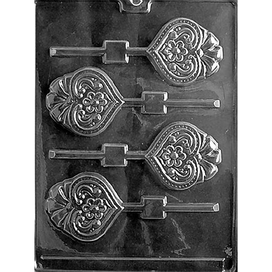 Clear plastic chocolate lollipop mold with four ornate heart cavities, each topped with a raised bow and detailed with a beaded border, scrollwork, and a small flower in the center, with stick channels attached.