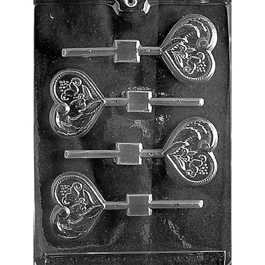 Clear plastic chocolate lollipop mold with four heart-shaped cavities featuring an ornate floral and leaf scroll pattern, each with a stick channel.