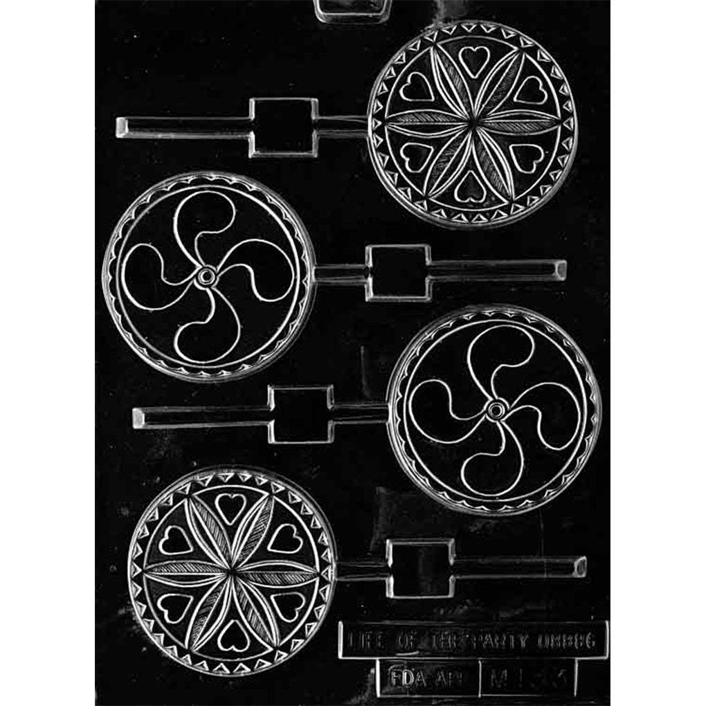 Clear chocolate lollipop mold with four round cavities featuring two folk-art patterns: one with small hearts around a flower-like center and one with a swirling pinwheel-style design.