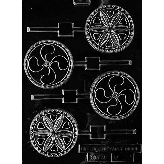 Clear chocolate lollipop mold with four round cavities featuring two folk-art patterns: one with small hearts around a flower-like center and one with a swirling pinwheel-style design.