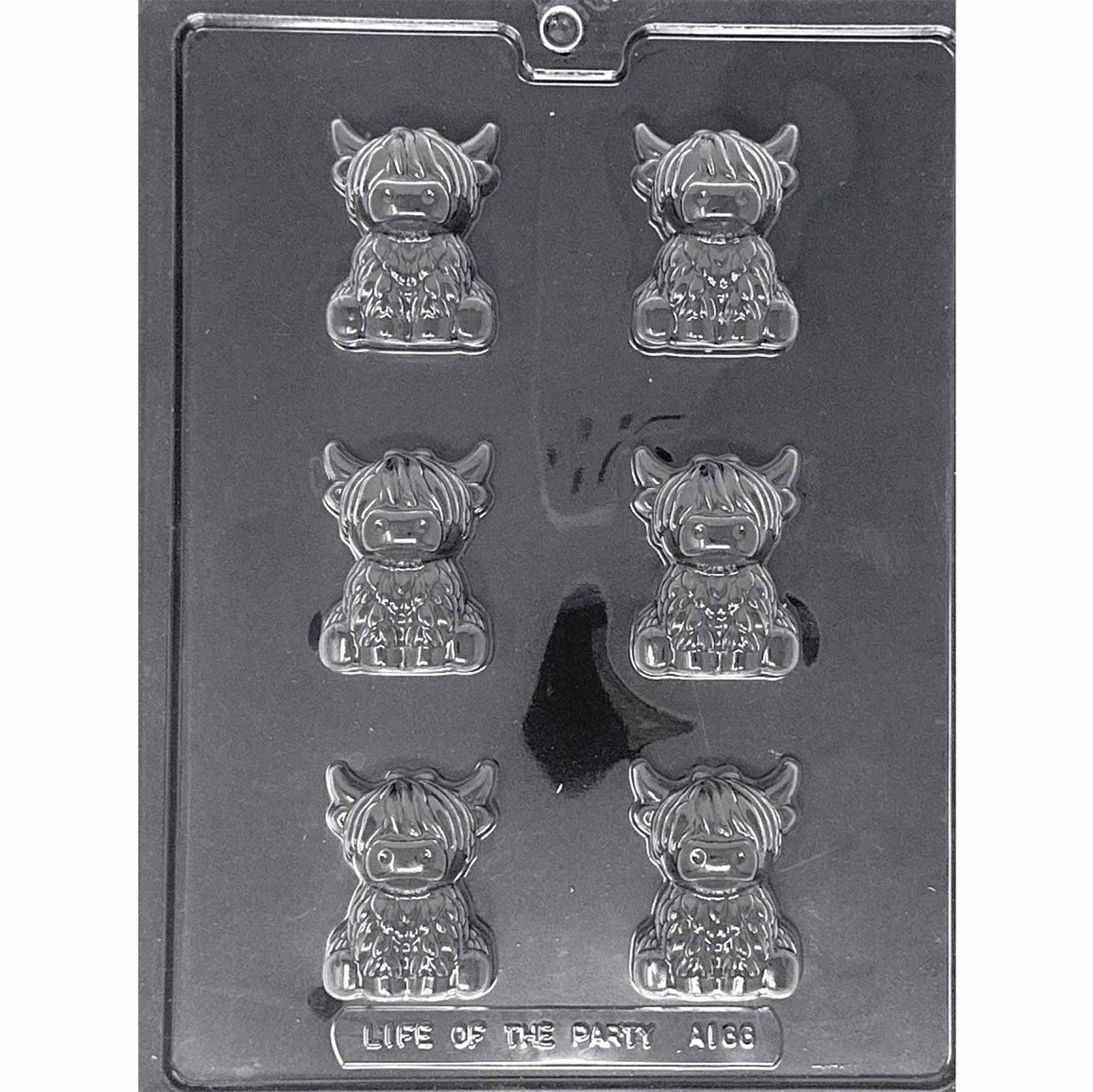Clear Highland Cow Chocolate Mold photographed against a black background with six seated shaggy cow cavities featuring long bangs, curved horns, broad noses, and hooves.