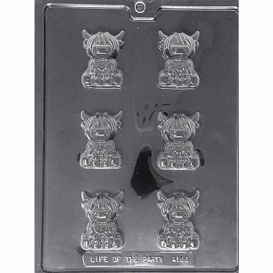 Clear Highland Cow Chocolate Mold photographed against a black background with six seated shaggy cow cavities featuring long bangs, curved horns, broad noses, and hooves.