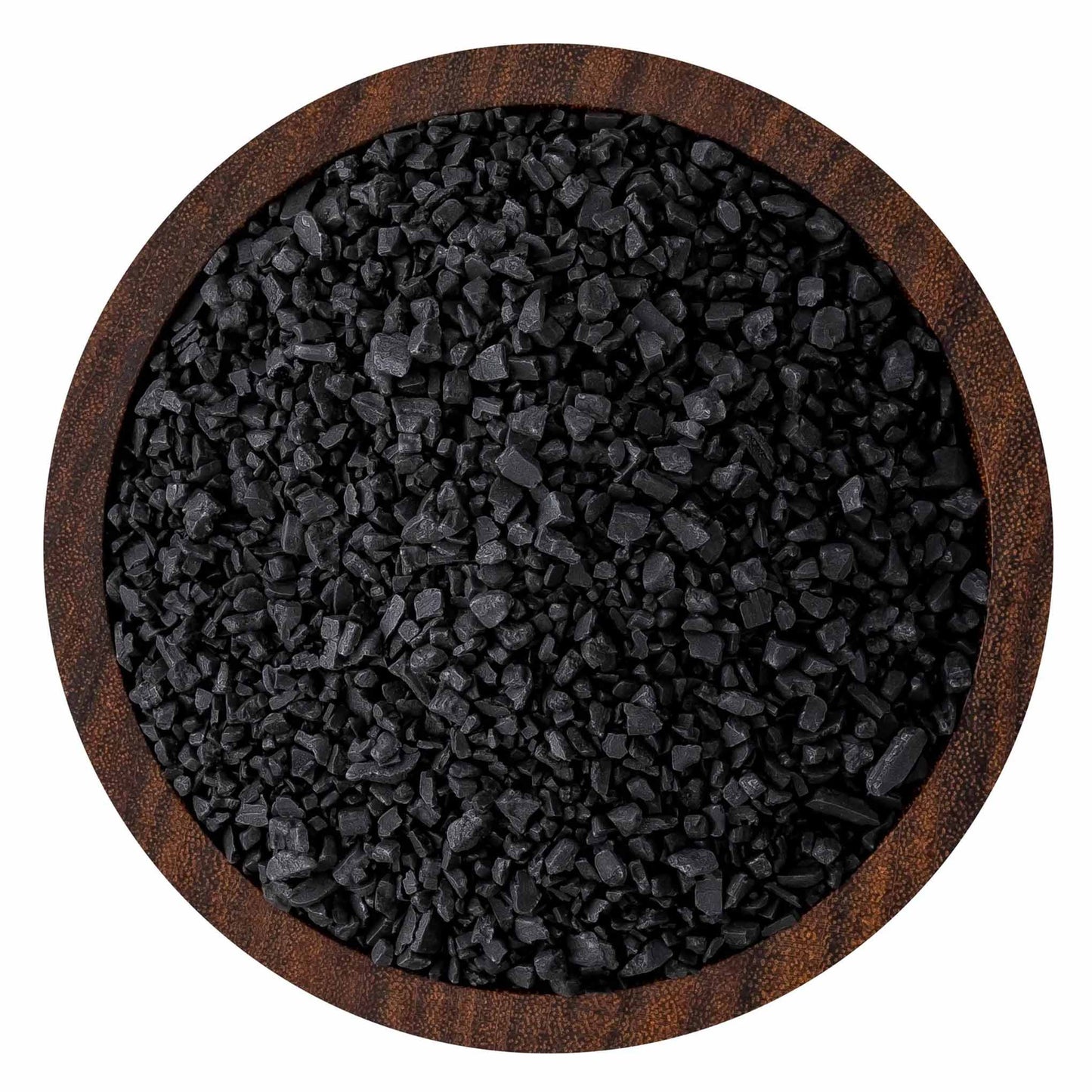 Top-down view of coarse black sea salt crystals in a round wooden bowl, showing jagged charcoal-black grains and textured wood rim.