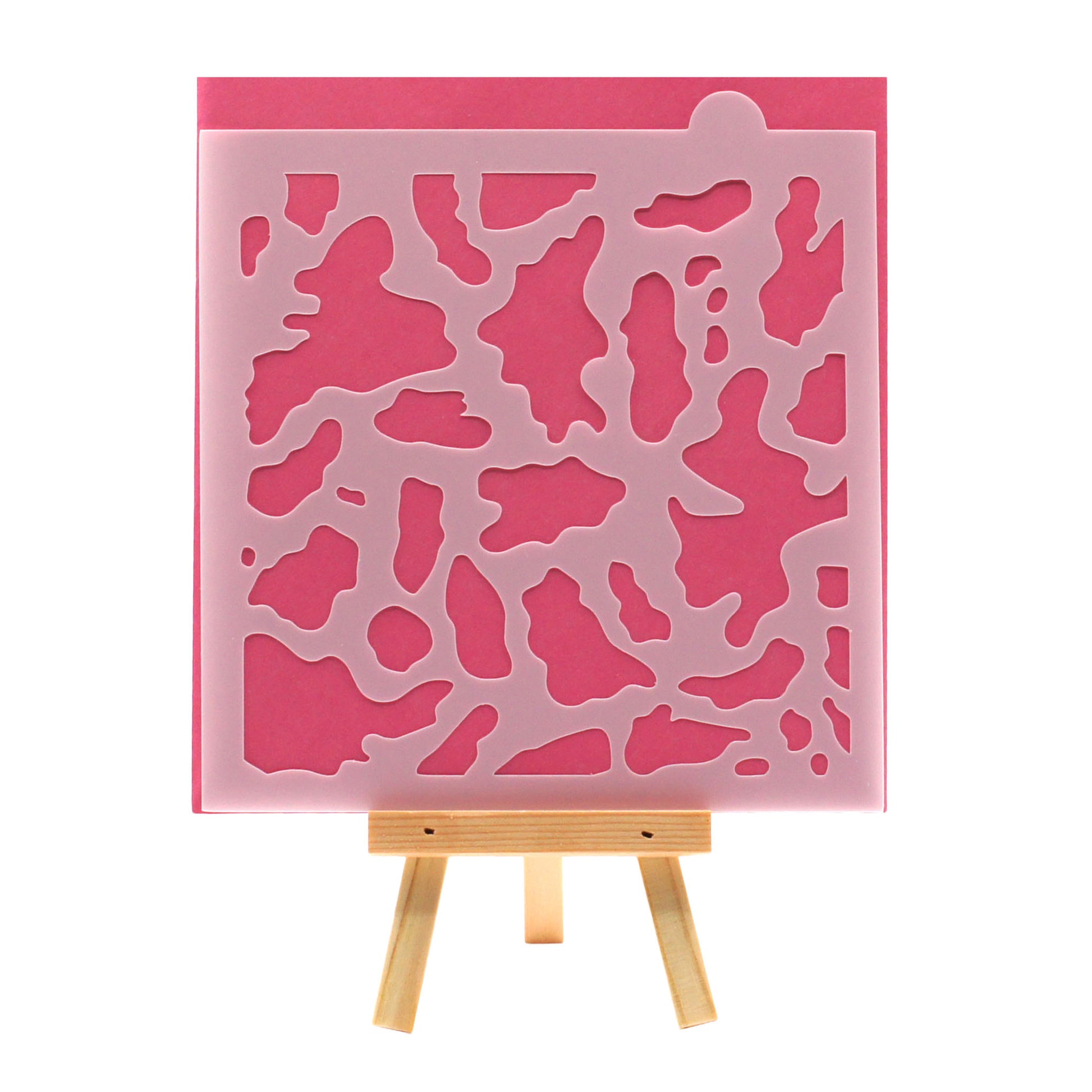 Cow print cookie stencil with an all-over scattered spot pattern on a square stencil sheet.