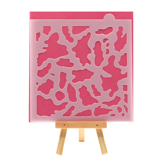 Cow print cookie stencil with an all-over scattered spot pattern on a square stencil sheet.