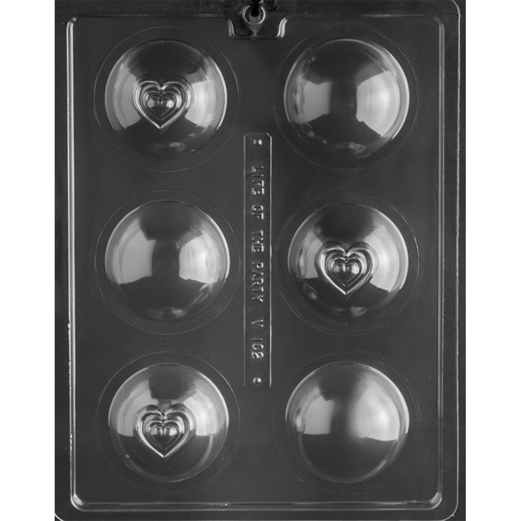 Six-cavity hot cocoa bomb chocolate mold with three plain half-spheres and three heart-detailed half-spheres, each measuring 2 3/8 inches across