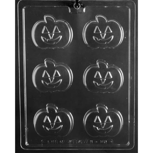 Clear plastic jack-o-lantern chocolate mold photographed on a black background with six pumpkin cavities, each showing triangle eyes and a smiling carved mouth.