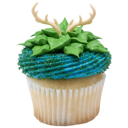 Cupcake decorated with green frosting leaves and blue sugar, topped with antler ring.
