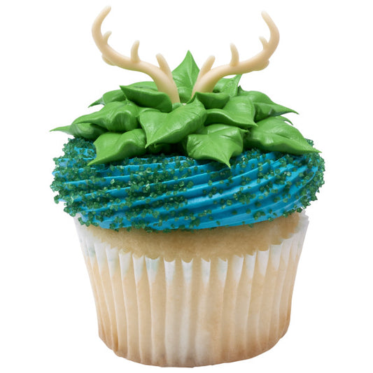 Cupcake decorated with green frosting leaves and blue sugar, topped with antler ring.
