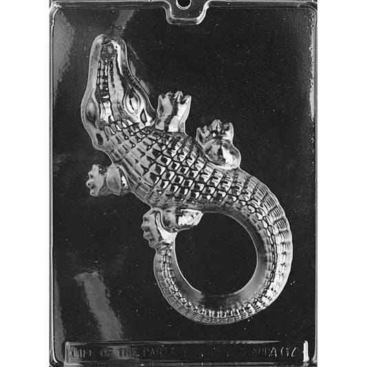 Clear chocolate mold with one large alligator cavity featuring textured scales, defined legs and feet, and a long tail curled into a loop on a dark background.