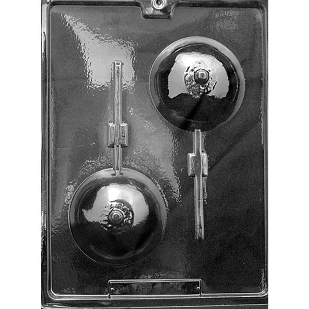 Clear plastic chocolate lollipop mold photographed against a dark background, featuring two round breast-shaped cavities with raised nipple details and channels for lollipop sticks.